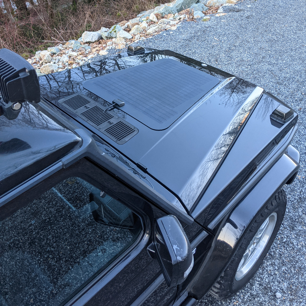 
A black mercedes-benz g-wagen wagon with a hood mounted solar panel system from cascadia 4x4, charge your solar generator jackery